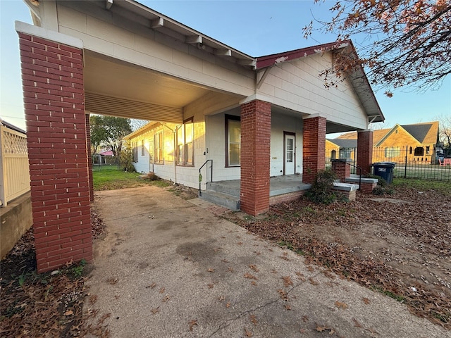 view of side of property featuring a porch and a carport