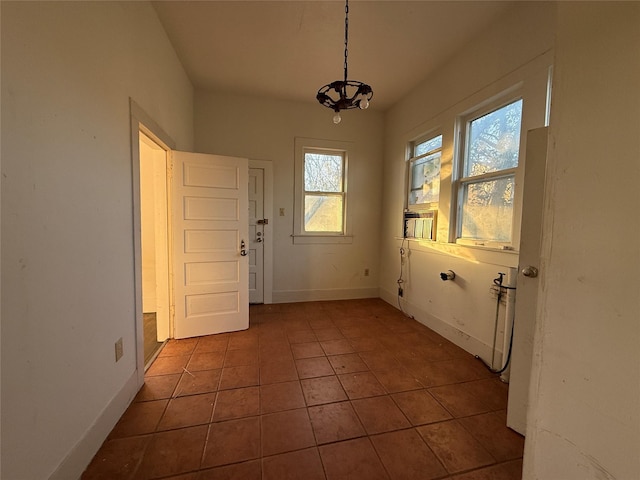 doorway to outside with dark tile patterned flooring