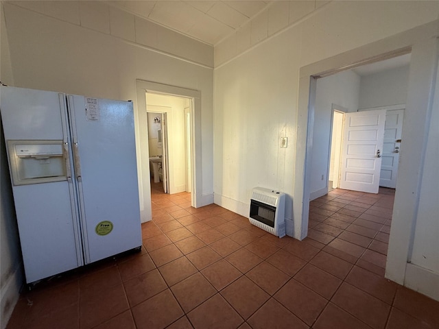 kitchen with white fridge with ice dispenser, heating unit, and dark tile patterned flooring