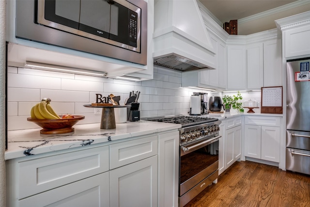 kitchen featuring white cabinets, custom exhaust hood, light stone countertops, and stainless steel appliances