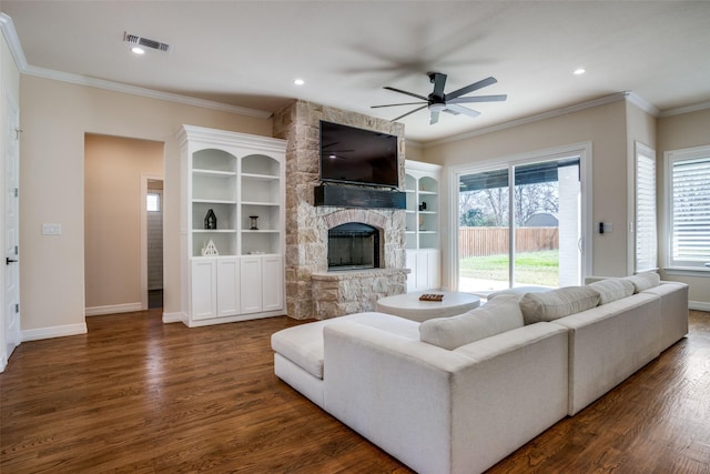 living room with ceiling fan, dark hardwood / wood-style floors, ornamental molding, and a fireplace