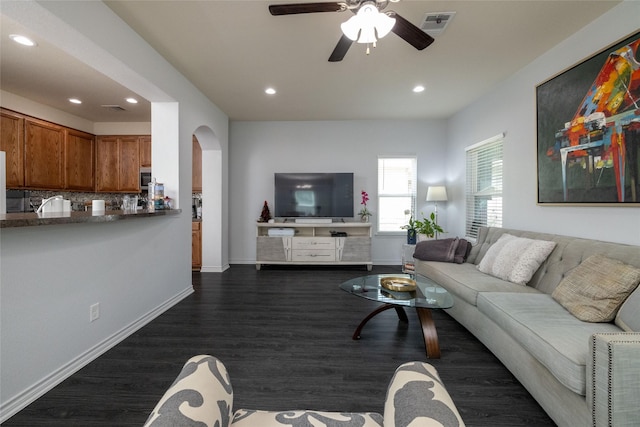 living room with ceiling fan and dark hardwood / wood-style flooring