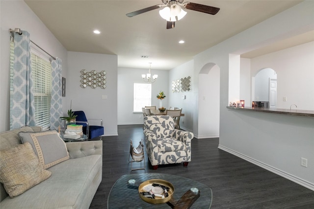 living room featuring dark hardwood / wood-style floors and ceiling fan with notable chandelier