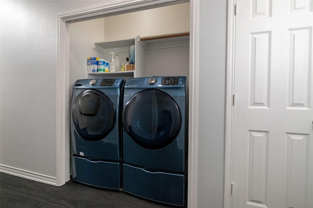 clothes washing area featuring dark hardwood / wood-style flooring and washing machine and clothes dryer