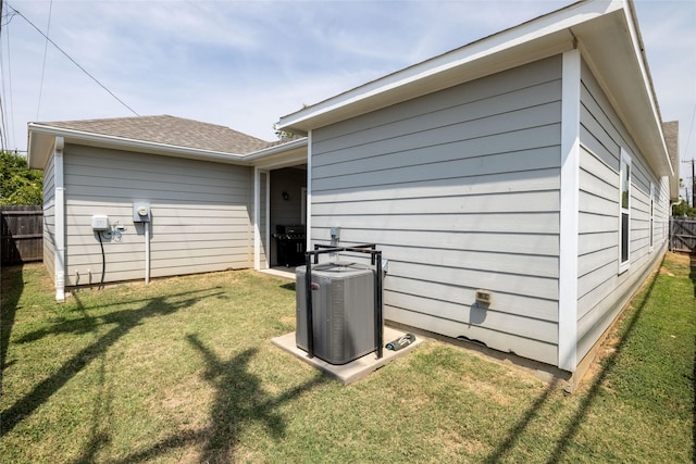 view of home's exterior with cooling unit and a lawn