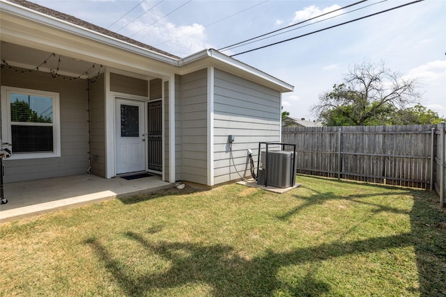 view of yard with central AC and a patio area