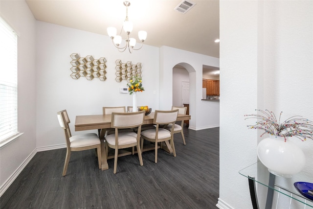 dining area with dark hardwood / wood-style flooring and a chandelier