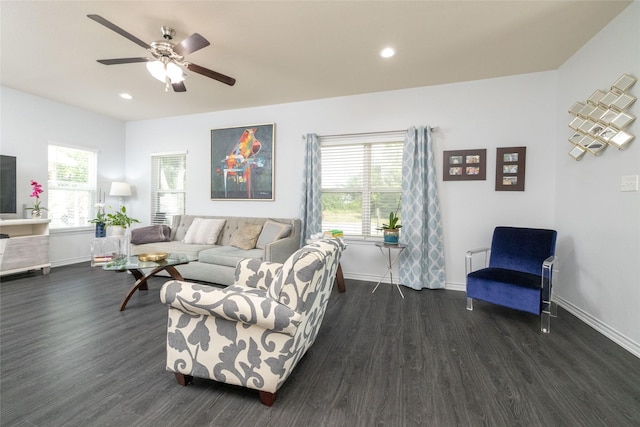 living room featuring dark wood-type flooring, ceiling fan, and a wealth of natural light