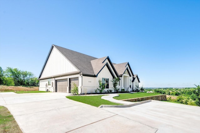 modern farmhouse style home with a front lawn and a garage