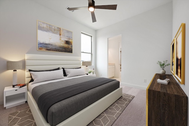 carpeted bedroom with ensuite bath and ceiling fan