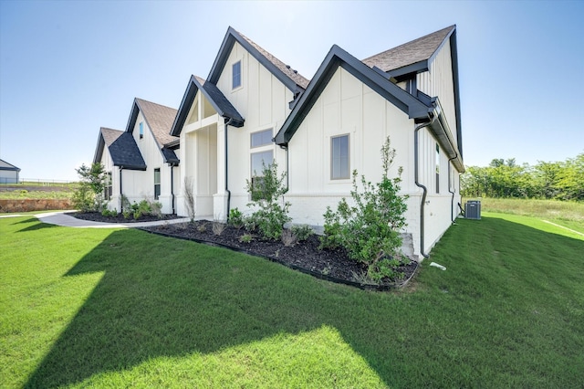 view of front of house with a front lawn and cooling unit