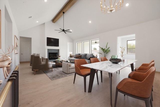 dining area featuring beamed ceiling, ceiling fan with notable chandelier, high vaulted ceiling, and light hardwood / wood-style flooring