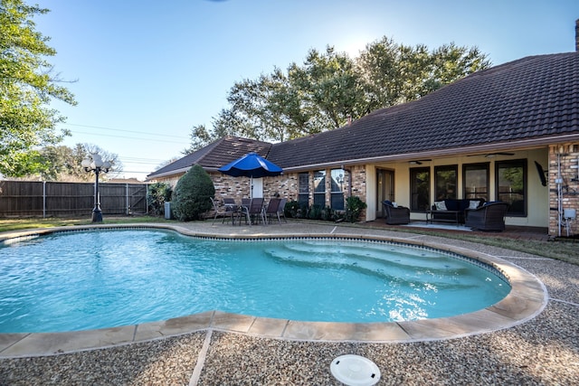 view of swimming pool featuring ceiling fan and a patio