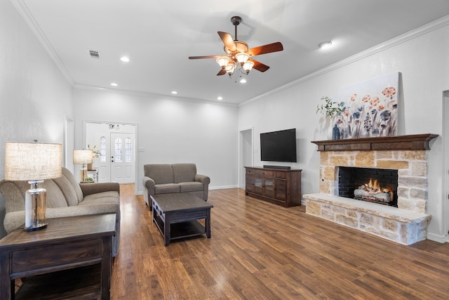 living room with a fireplace, dark hardwood / wood-style floors, ceiling fan, and ornamental molding