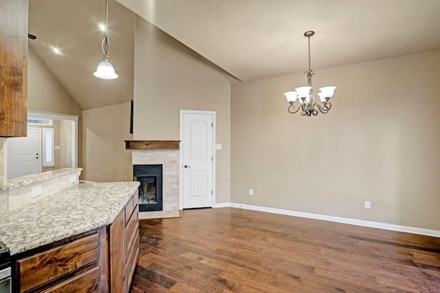 kitchen with an inviting chandelier, dark hardwood / wood-style flooring, high vaulted ceiling, and hanging light fixtures