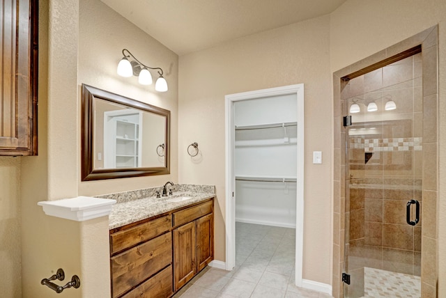 bathroom with tile patterned floors, vanity, and a shower with shower door