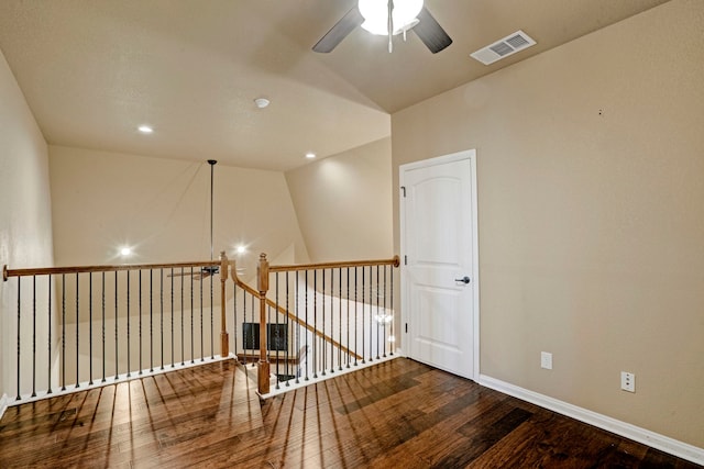 empty room with ceiling fan, vaulted ceiling, and hardwood / wood-style floors