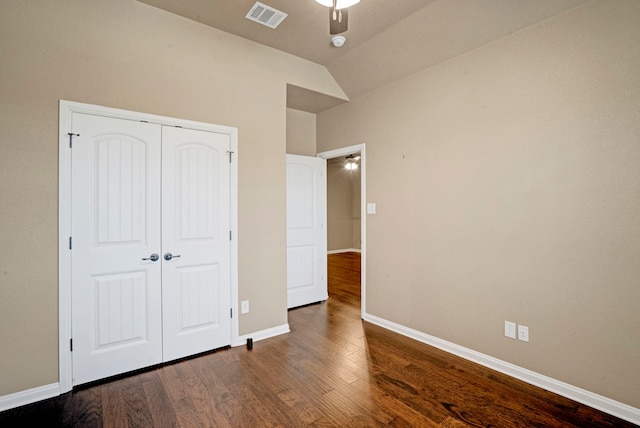 unfurnished bedroom with lofted ceiling, dark hardwood / wood-style floors, and a closet