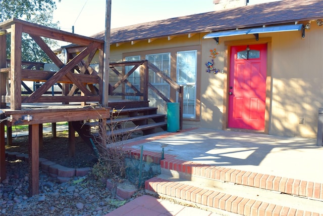 view of exterior entry with a patio