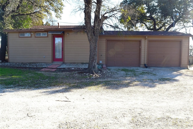 single story home with a garage and an outbuilding