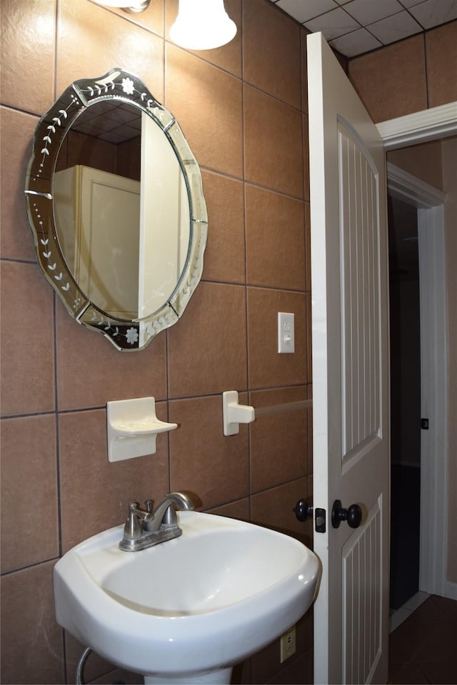 bathroom featuring tile walls and sink