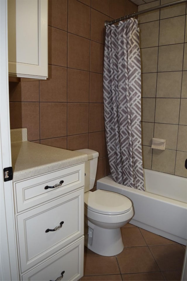 full bathroom featuring shower / tub combo with curtain, tile walls, tile patterned flooring, vanity, and toilet