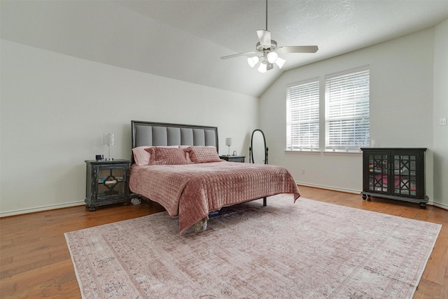 bedroom featuring light hardwood / wood-style floors, ceiling fan, and lofted ceiling