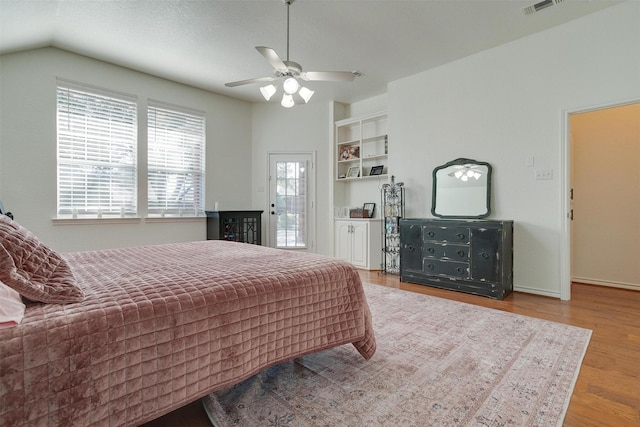 bedroom with hardwood / wood-style flooring, ceiling fan, and vaulted ceiling