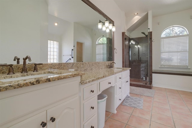 bathroom with tile patterned flooring, vanity, vaulted ceiling, and walk in shower