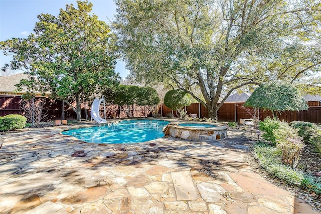 view of swimming pool with a patio area, an in ground hot tub, and a water slide