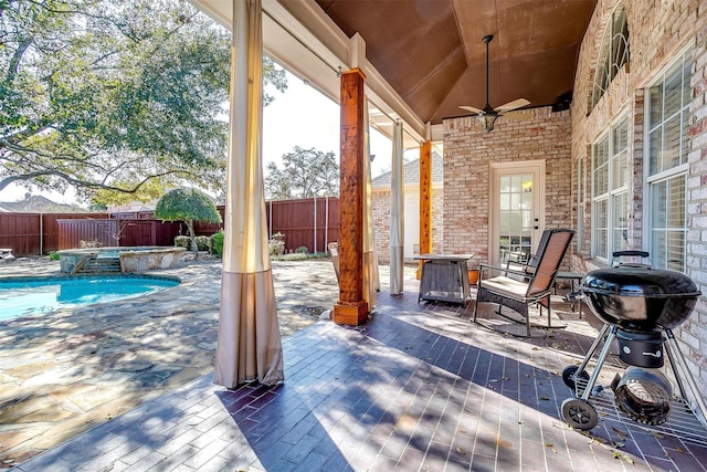 view of patio / terrace featuring ceiling fan and a pool with hot tub