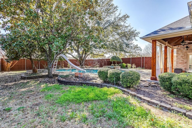 view of yard with ceiling fan and a fenced in pool