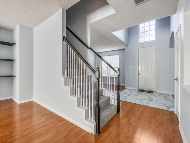 foyer entrance with plenty of natural light, hardwood / wood-style floors, and a textured ceiling