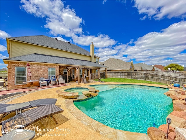 view of swimming pool featuring an in ground hot tub and a patio