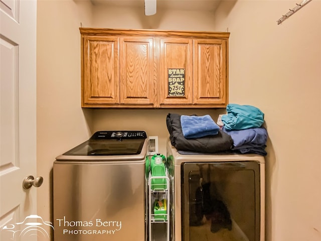 laundry area with washing machine and clothes dryer and cabinets