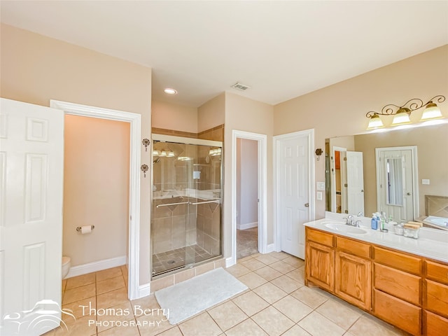 bathroom featuring toilet, tile patterned flooring, vanity, and walk in shower