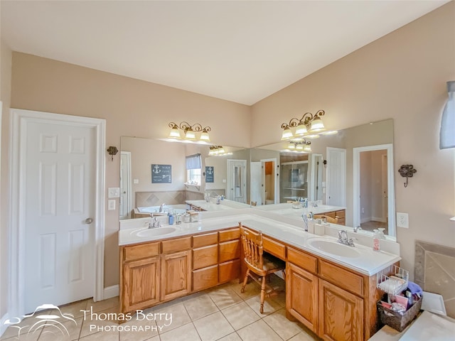 bathroom with tile patterned floors, a tub, and vanity