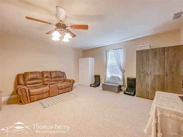 carpeted living room with ceiling fan