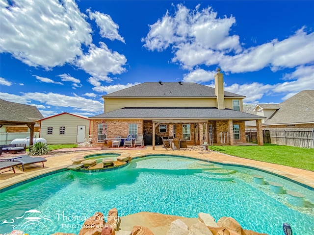 view of swimming pool with an in ground hot tub, a patio, and a lawn