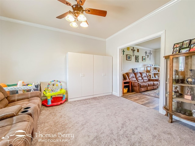 carpeted living room with ceiling fan and crown molding