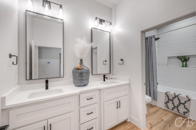 full bathroom featuring vanity, hardwood / wood-style flooring, toilet, and shower / bathtub combination with curtain