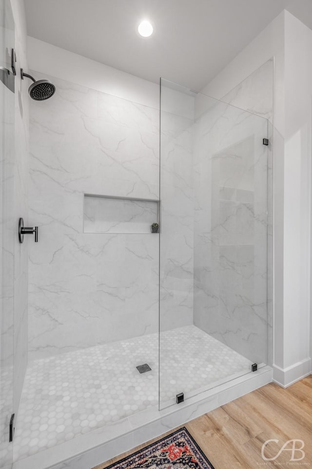 bathroom featuring hardwood / wood-style flooring and a shower with shower door