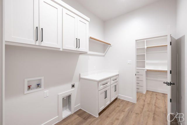 laundry room featuring hookup for an electric dryer, cabinets, hookup for a washing machine, and light hardwood / wood-style flooring