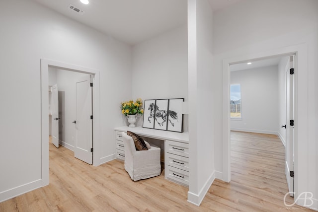 office space with light hardwood / wood-style flooring and built in desk