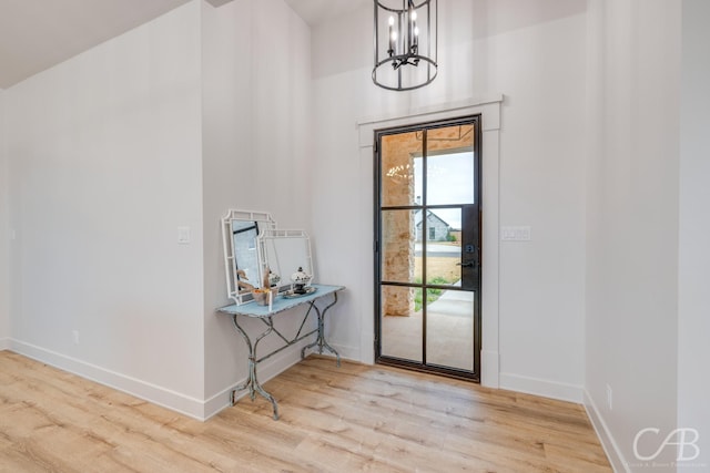 entryway with light hardwood / wood-style flooring and an inviting chandelier