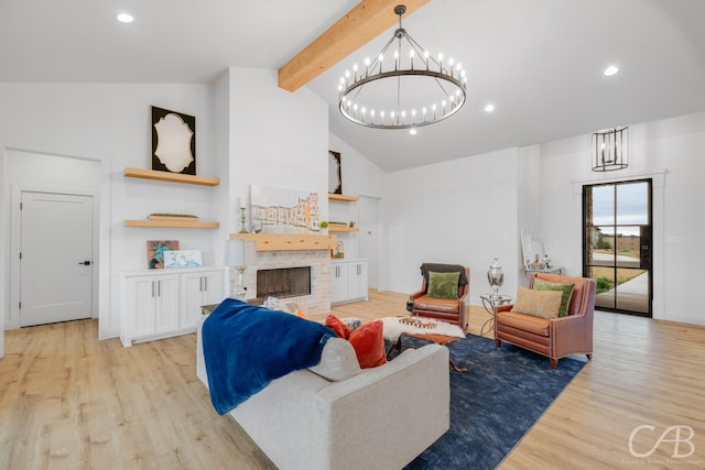 living room with vaulted ceiling with beams, a fireplace, light hardwood / wood-style floors, and a notable chandelier