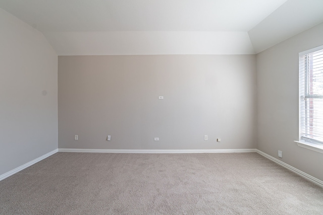 spare room with vaulted ceiling, plenty of natural light, and carpet flooring