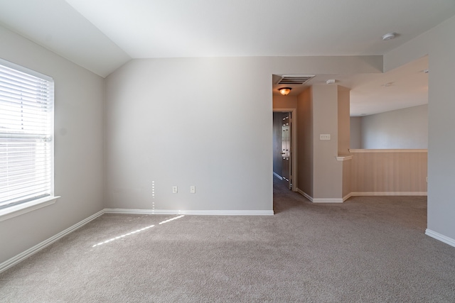 spare room with lofted ceiling and carpet flooring