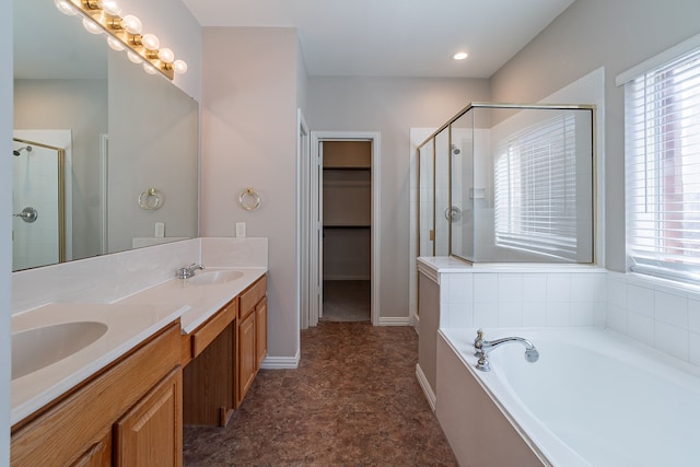 bathroom featuring vanity, plus walk in shower, and a healthy amount of sunlight