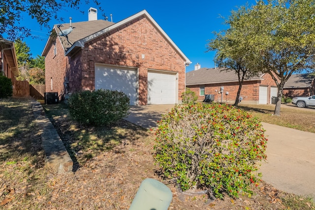 view of side of property featuring a garage, an outdoor structure, and central air condition unit